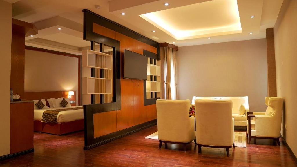 Best Western Plus Pearl Addis في أديس أبابا: غرفة فندقية بسرير وطاولة وكراسي
