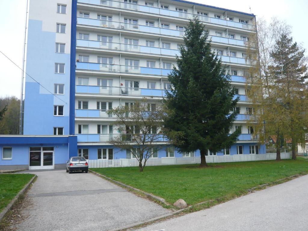 a large blue building with a car parked in front of it at Apartmá Ježková in Vrchlabí