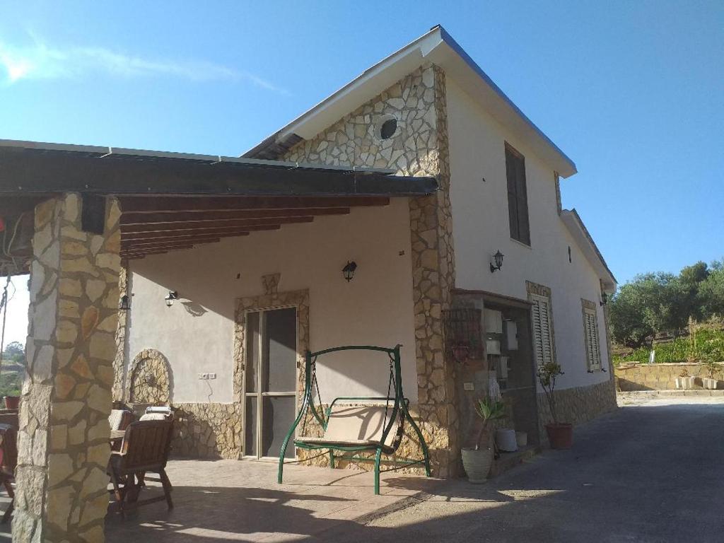 ein Gebäude mit einer Veranda mit einem Stuhl darauf in der Unterkunft Villetta Torre Salsa in Siculiana