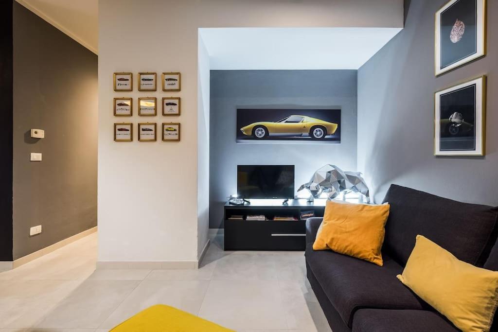 un salon avec une voiture jaune sur le mur dans l'établissement Harinero, characteristic apartment in the center, à SantʼAgata Bolognese