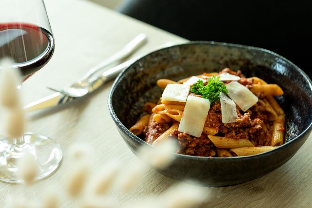a bowl of pasta with cheese on a table at Holiday Inn Express Amsterdam - North Riverside by IHG in Amsterdam