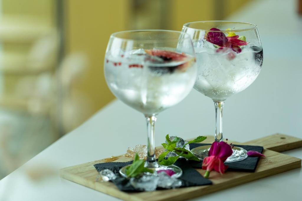 two wine glasses on a wooden tray with flowers at Holiday Inn Express Amsterdam - North Riverside by IHG in Amsterdam