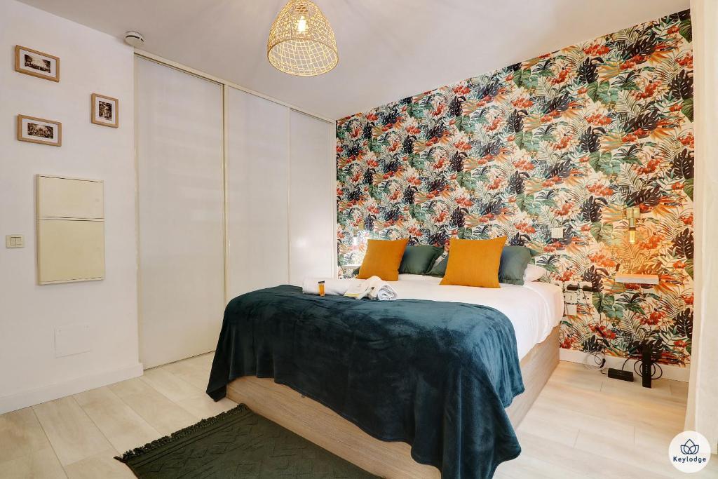 - une chambre avec un lit et un grand papier peint floral dans l'établissement Studio classé 2 étoiles - L'Eden - Saint-Denis, à Saint-Denis