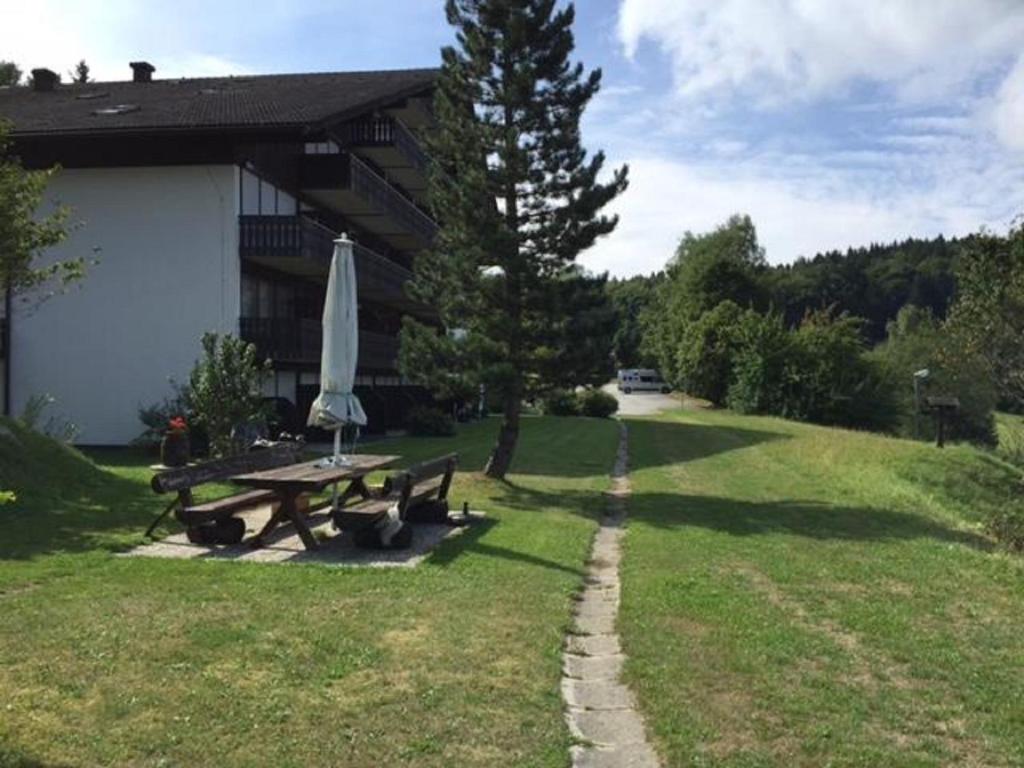 a picnic table with an umbrella in a yard at PfiffiApart in Schöfweg