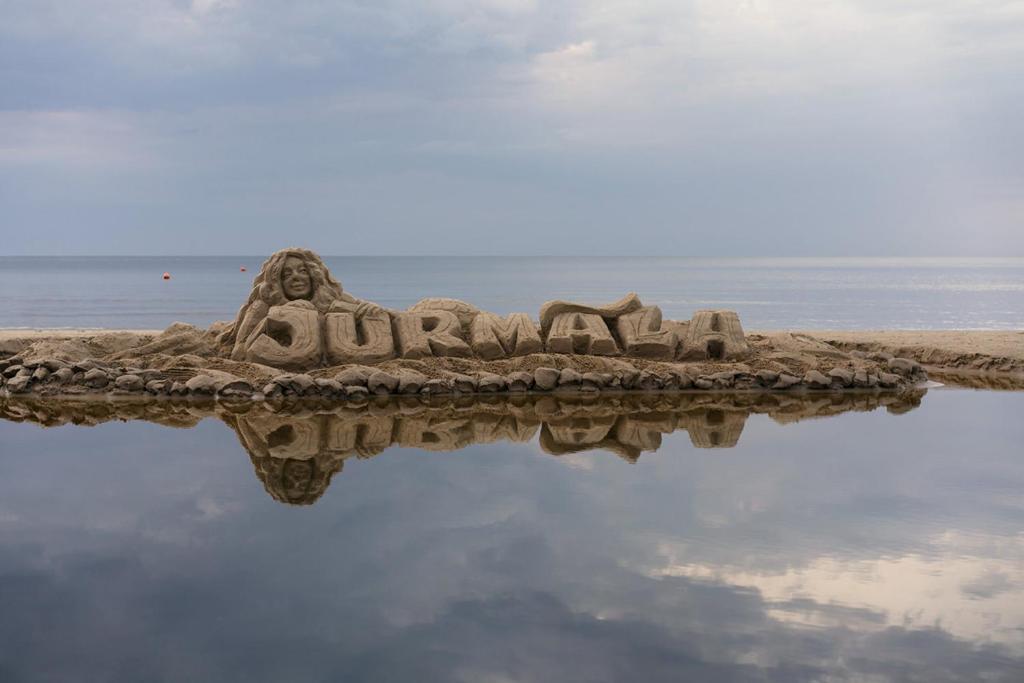 a sandcastle on the beach with its reflection in the water at Old villa Kaprice Baltic Beach in Jūrmala