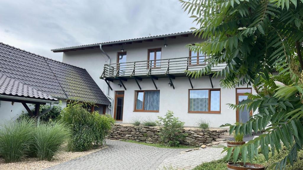 a white house with a balcony on top of it at Penzion Kundratice in Kundratice