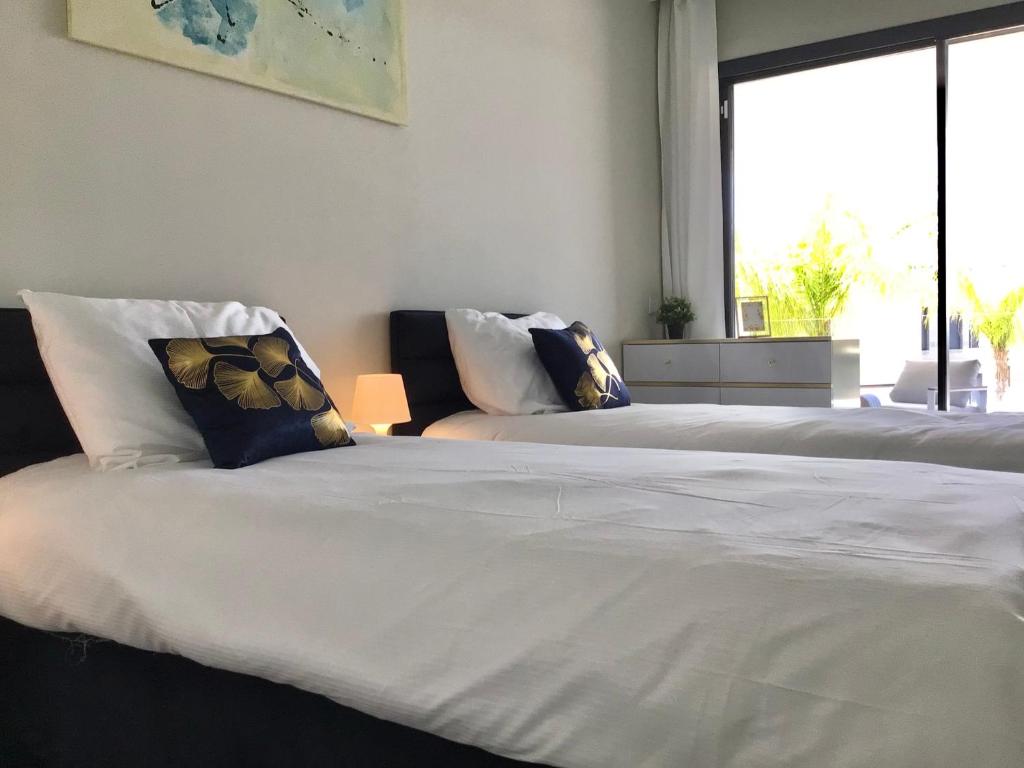 - 2 lits blancs dans une chambre avec fenêtre dans l'établissement The View Luxury Vacation Apartment Blue, à Fuengirola
