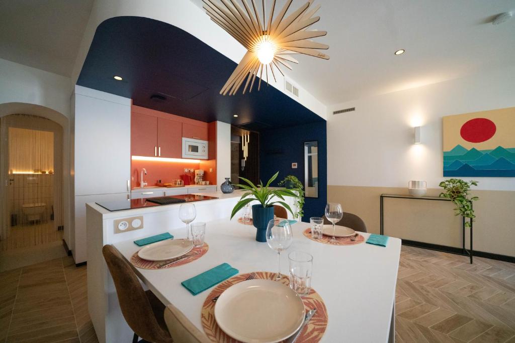 a dining room and kitchen with a table and chairs at Roma Divine home cinéma et jardin in Nîmes