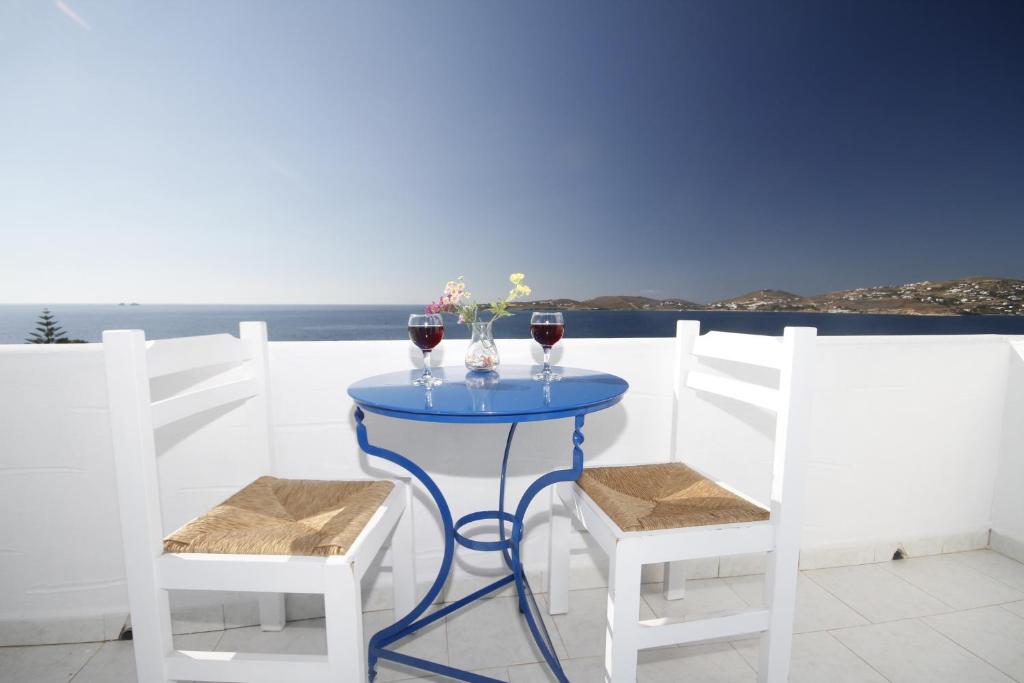 a table with two glasses of wine and two chairs at Stratos Apartments & Studios in Parikia