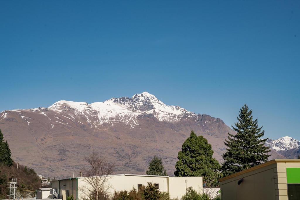 a mountain with snow capped mountains in the background at Snowy Peaks - Queenstown Holiday Apartment in Queenstown