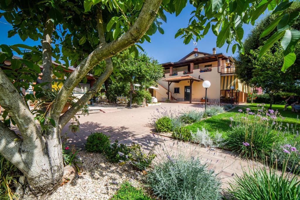 un jardín frente a una casa en I Lecci Guesthouse en San Felice Circeo