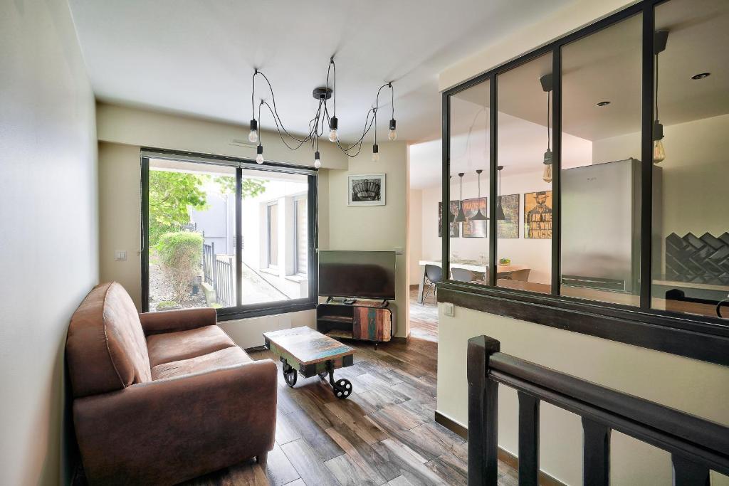 ein Wohnzimmer mit einem Stuhl und einem Tisch in der Unterkunft Bel appartement idéal pour 4 personnes, 2 chambres in Paris