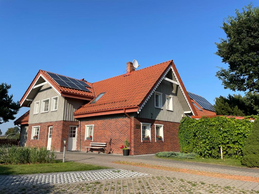 une maison avec des panneaux solaires sur le toit dans l'établissement Mono House, à Rusnė