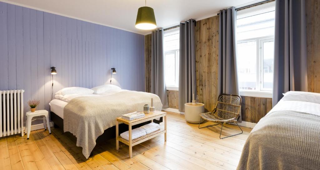 a bedroom with two beds and a table at Old Charm Reykjavik Apartments in Reykjavík