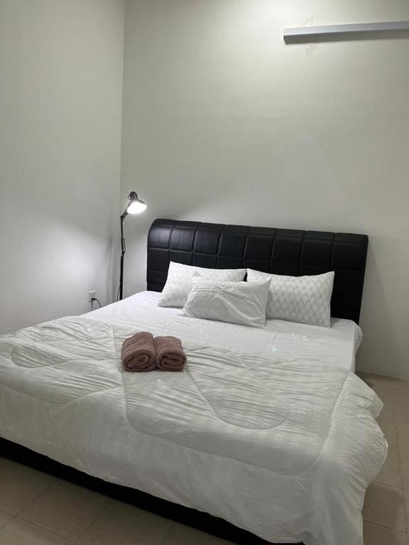 - un grand lit blanc avec 2 serviettes dans l'établissement OrchidVilla Homestay at Southville Apartment, à Kampong Parit