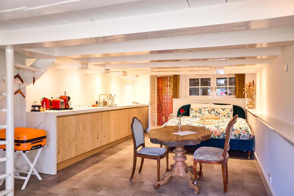 eine Küche und ein Esszimmer mit einem Tisch und Stühlen in der Unterkunft Studio next to Skinny Bridge near Rembrandtsquare in Amsterdam