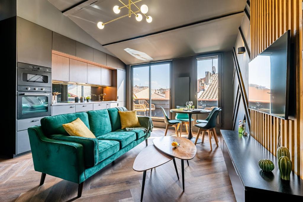 sala de estar con sofá verde y mesa en LOFT EN VILLE - Duplex Terrasse coeur historique avec vue dégagée & Parking souterrain Offert, en La Ciotat