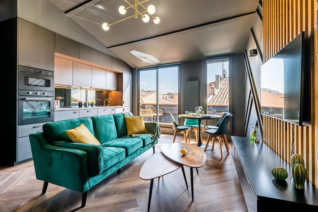 un salon avec un canapé vert et une table dans l'établissement LOFT EN VILLE - Duplex Terrasse coeur historique avec vue dégagée & Parking souterrain Offert, à La Ciotat