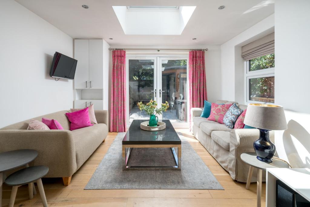 sala de estar con sofá y mesa en JOIVY 2-bed flat with garden in Battersea en Londres