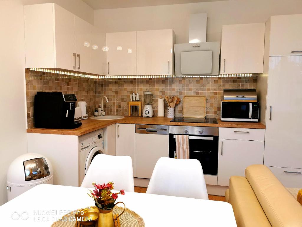 una cocina con armarios blancos y electrodomésticos blancos en PARKIDYLLE (Familien Apartment, 3 Zimmer,2 Schlafzimmer,Balkon), en Świnoujście