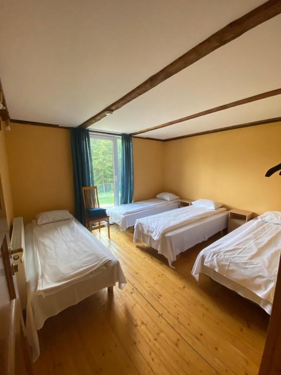 een kamer met 3 bedden en een raam bij Kooli talu puhkemaja in Valingu