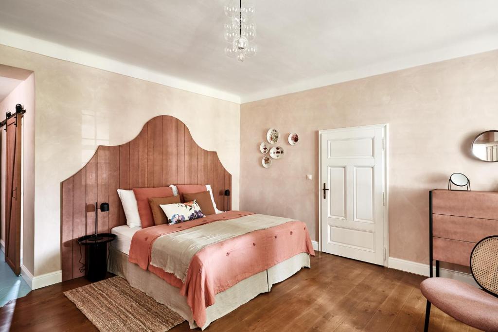 Un dormitorio con una cama grande y una lámpara de araña. en Zámek Žďár, en Žďár nad Sázavou