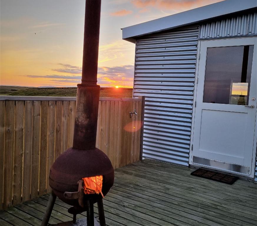 a woodburning stove on a deck with a house at Tiny and cosy house in the countryside in Hella