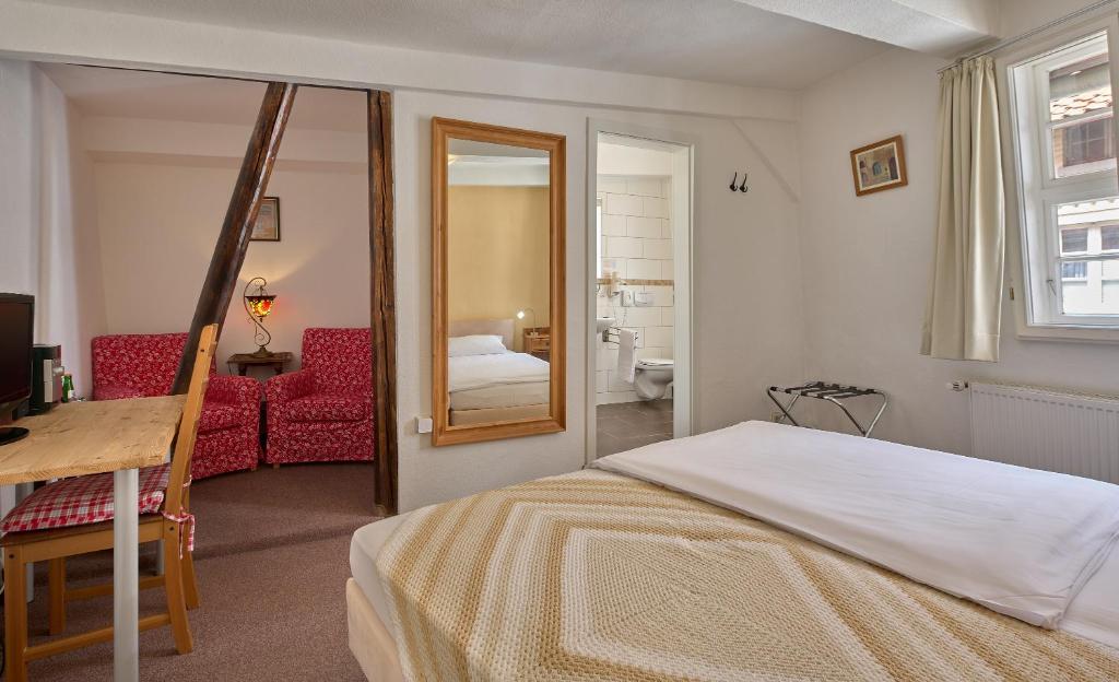 ein Schlafzimmer mit einem Bett und ein Zimmer mit einem Bad in der Unterkunft Pension-Ristorante Ventura ehemals Reinhards Pension in Hornburg