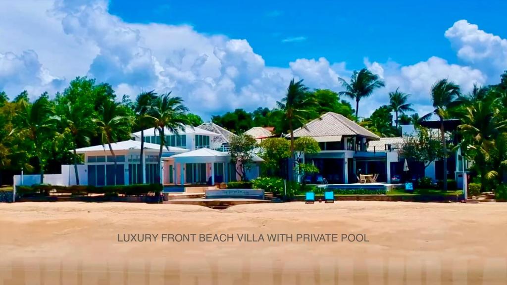 ラヨーンにあるSamet View Luxury Villa with Private Poolのヤシの木が植えられた浜辺の家