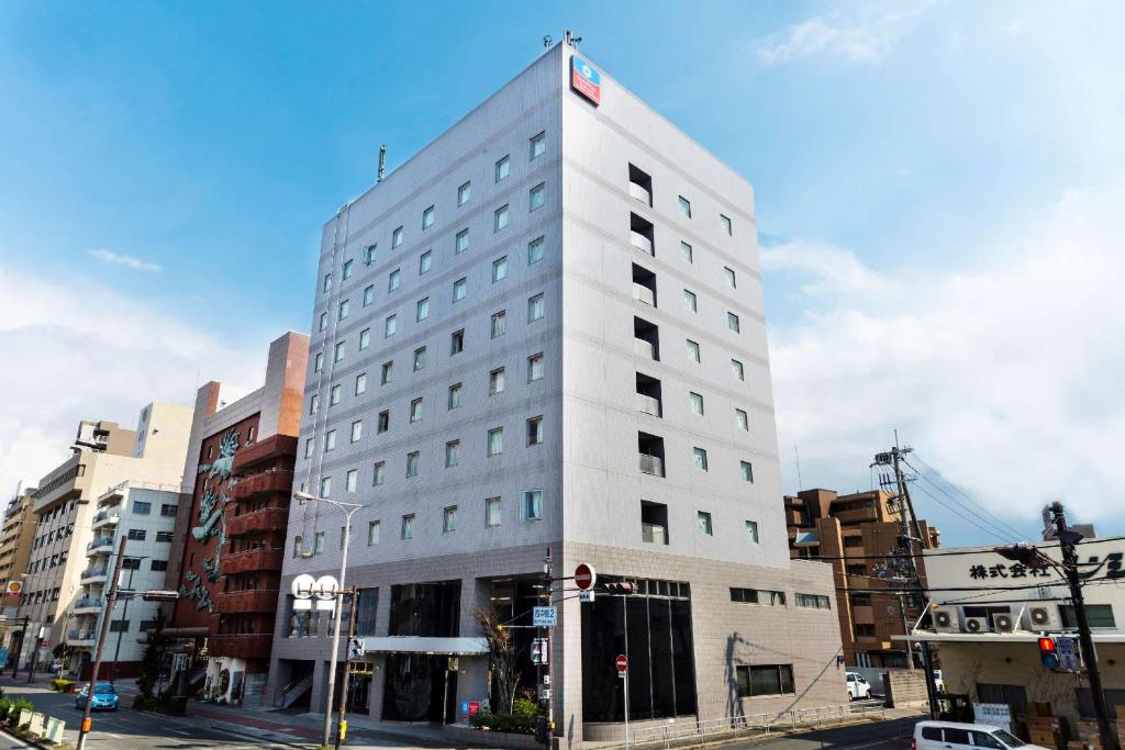 a tall white building on a city street at SureStay Plus Hotel by Best Western Shin-Osaka in Osaka