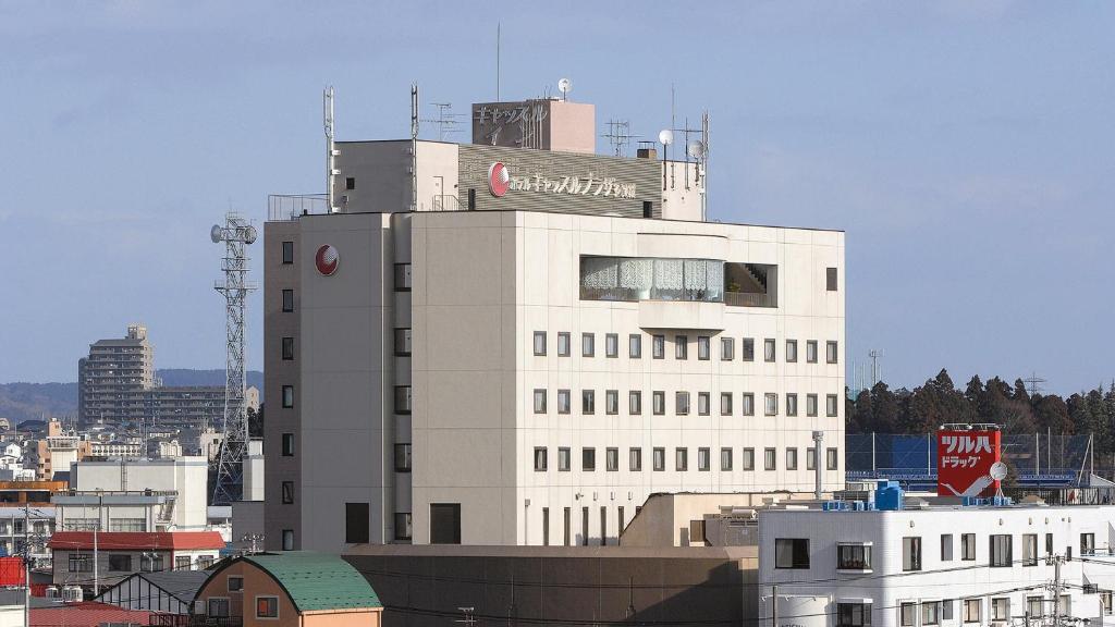 ein weißes Gebäude mit einem Schild darüber in der Unterkunft Hotel Castle Plaza Tagajo in Tagajo