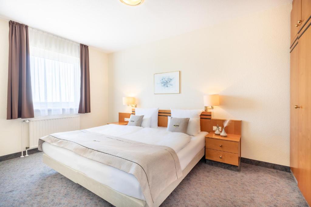 ライプツィヒにあるacora Leipzig Living the Cityの白い大きなベッドルーム(大型ベッド1台、窓付)が備わります。