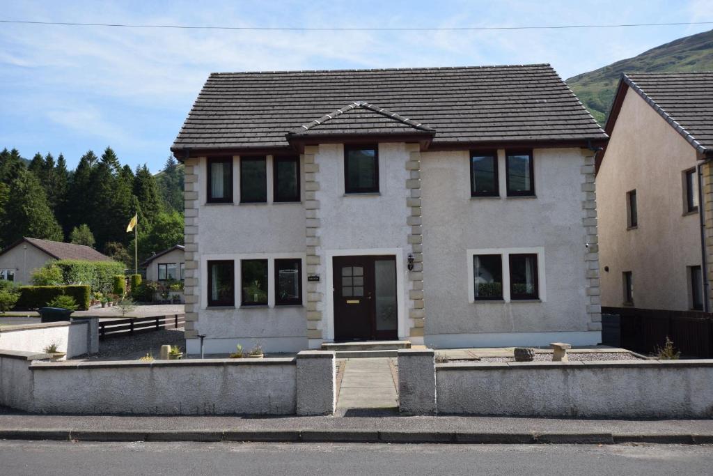 a white house with a black roof at Ridgeview Villa - Partial loch view in Lochgoilhead