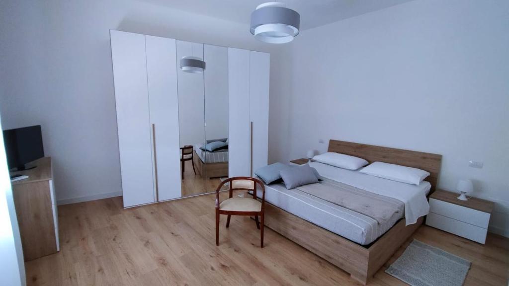um quarto com uma cama, uma cadeira e um espelho em Helianthus em Assemini