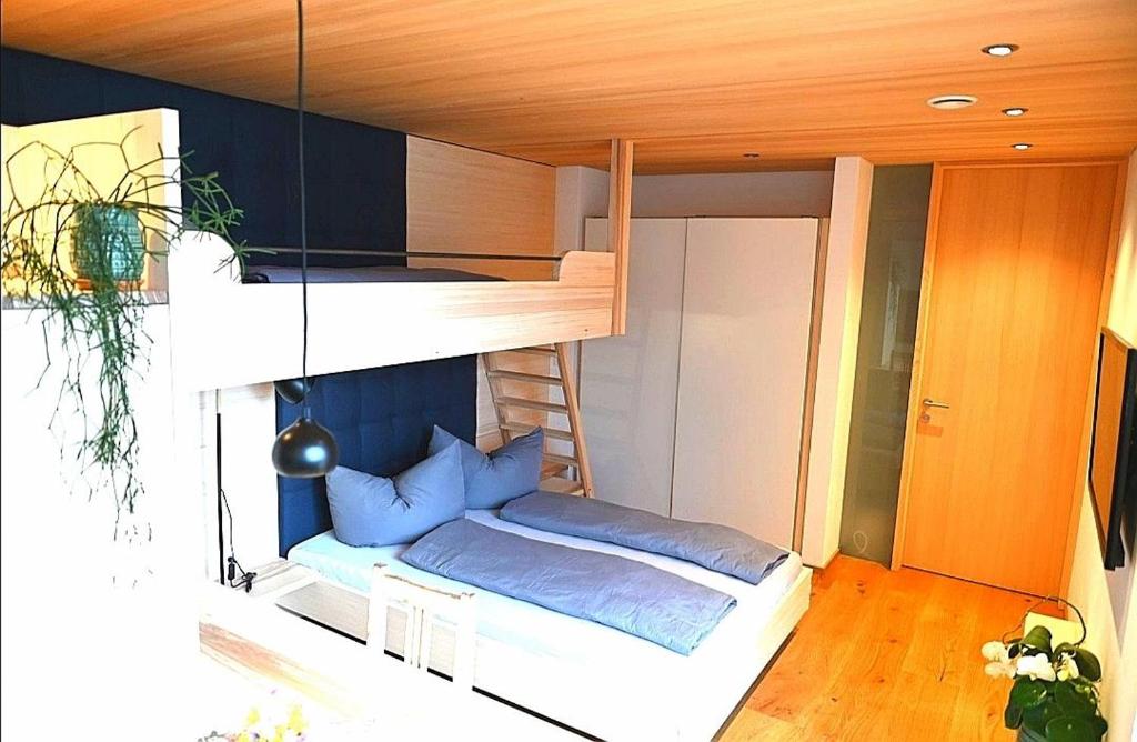 een slaapkamer met een stapelbed met blauwe kussens bij Apartment BergIN in Raggal