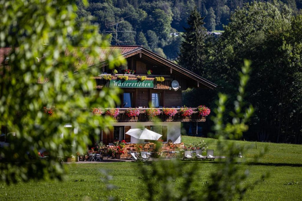 um edifício com uma varanda com flores em Wassererlehen em Bischofswiesen