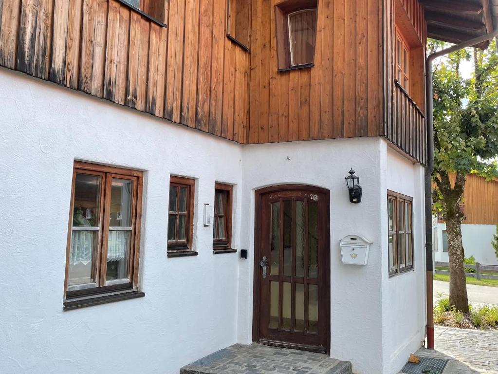 een huis met een houten muur en een deur bij Haus Kreiznegge - Chiemgau Karte in Inzell