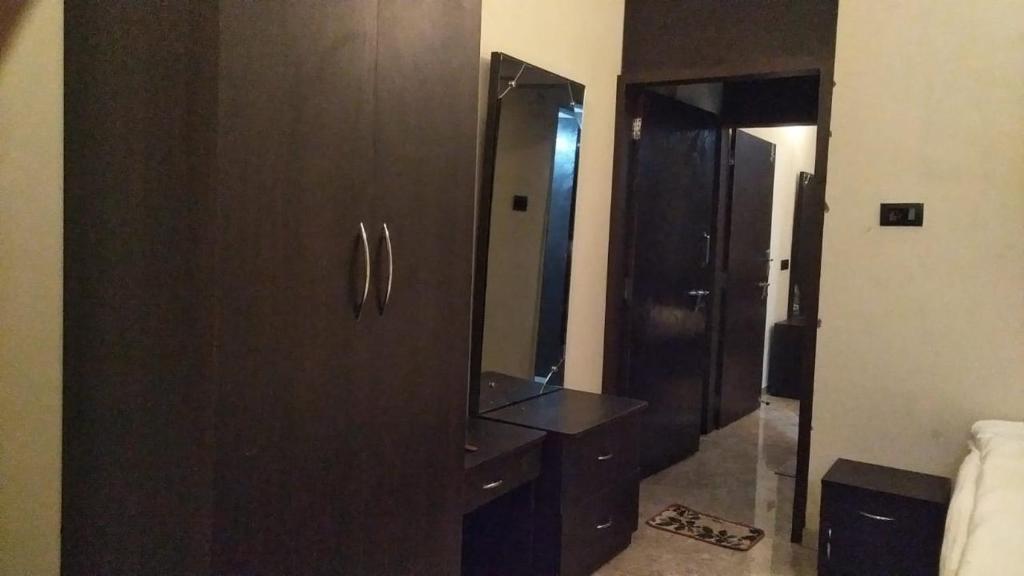 a bathroom with a wooden cabinet and a mirror at Jayshin Lake Vaitarna Resort - Igatpuri in Igatpuri