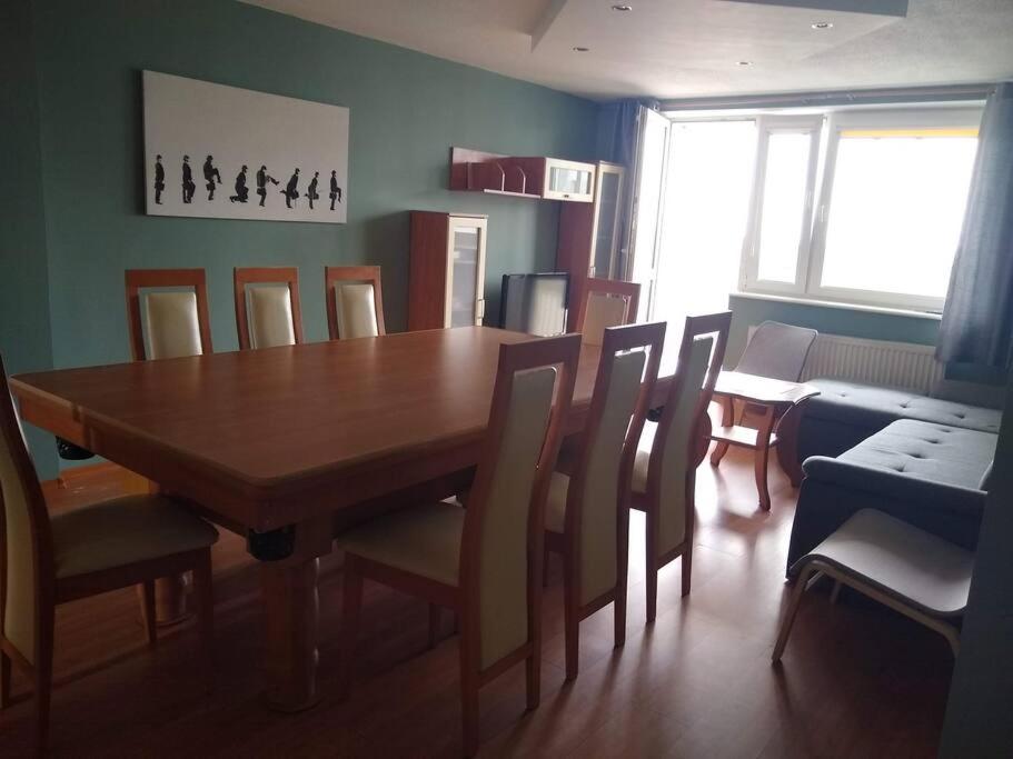 a dining room with a wooden table and chairs at Apartament z widokiem na Zatokę, Hel, Port i lasy in Gdańsk