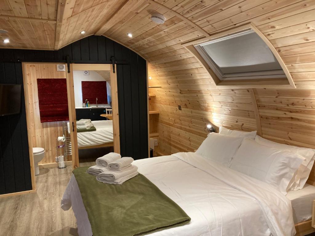 1 dormitorio con 1 cama blanca grande en una habitación en Bedrule Old Manse Glamping, en Hawick