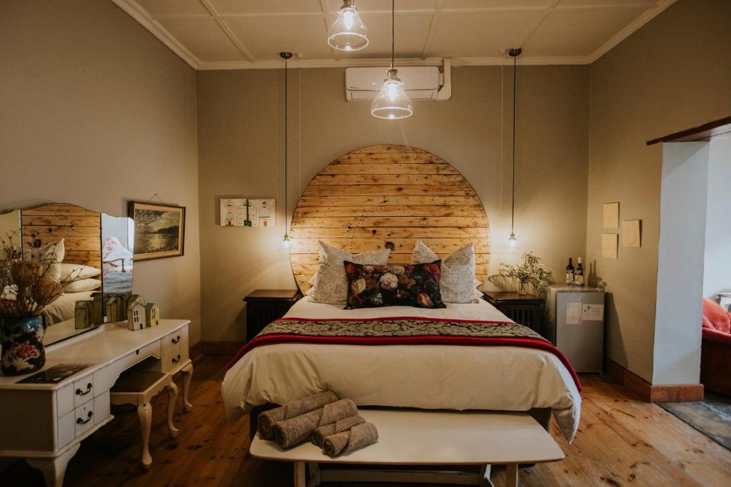 a bedroom with a large bed and a wooden wall at three birds country house in Richmond