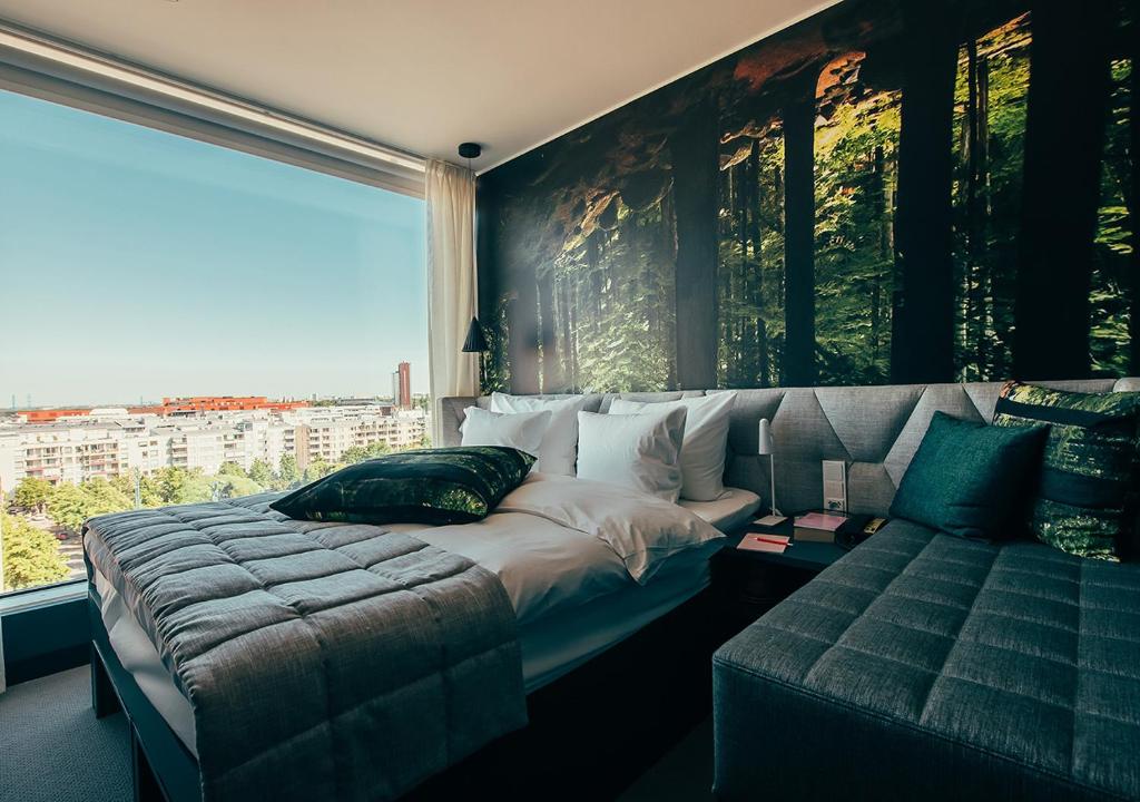 a bedroom with a bed and a couch and a window at Hotel AX in Helsinki