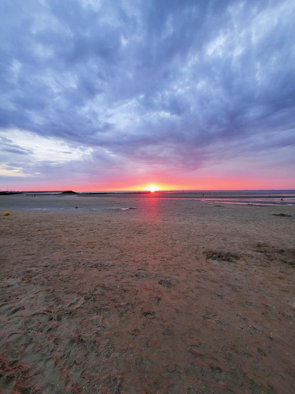 zachód słońca na plaży w oddali w obiekcie Studio Jeannette avec Balcon et juste à 130 metres Plage ! Plein Centre ! Wifi - Draps Serviettes inclus ! w mieście Trouville-sur-Mer