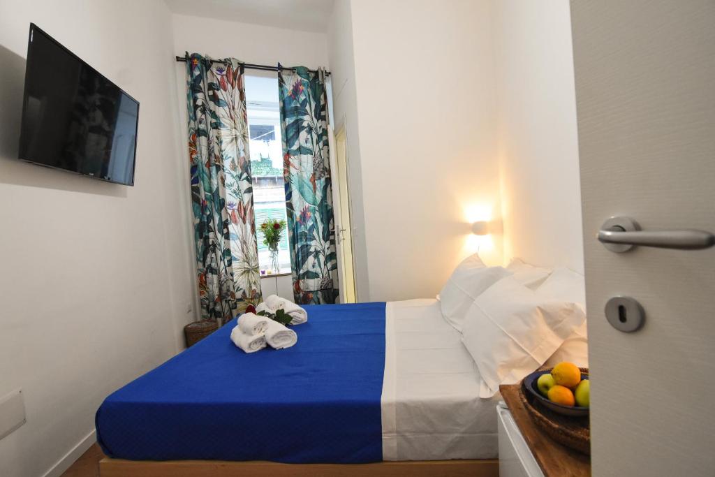La Dimora di Artemide B&B في نابولي: غرفة نوم بسرير ازرق وبيض مع صحن فواكه