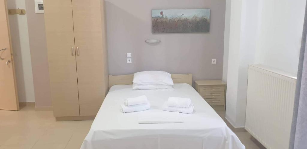 Zimmer mit einem Bett mit weißer Bettwäsche und Handtüchern in der Unterkunft Achilleas Apartments in Paralia Skotinas