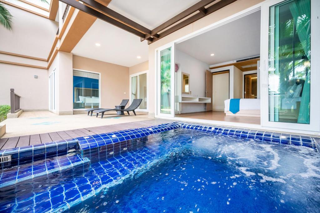 an indoor pool in a house with a swimming pool at Hotel COCO Phuket Bangtao - SHA Extra Plus in Bang Tao Beach