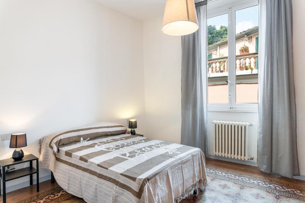 um quarto com uma cama e uma grande janela em Appartamento Galgani - Affitti Brevi Italia em Lucca