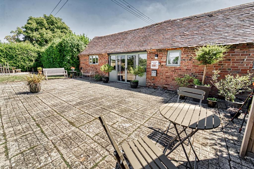 a patio in front of a brick building at Guest Homes - Snodsbury Barn in Upton Snodsbury
