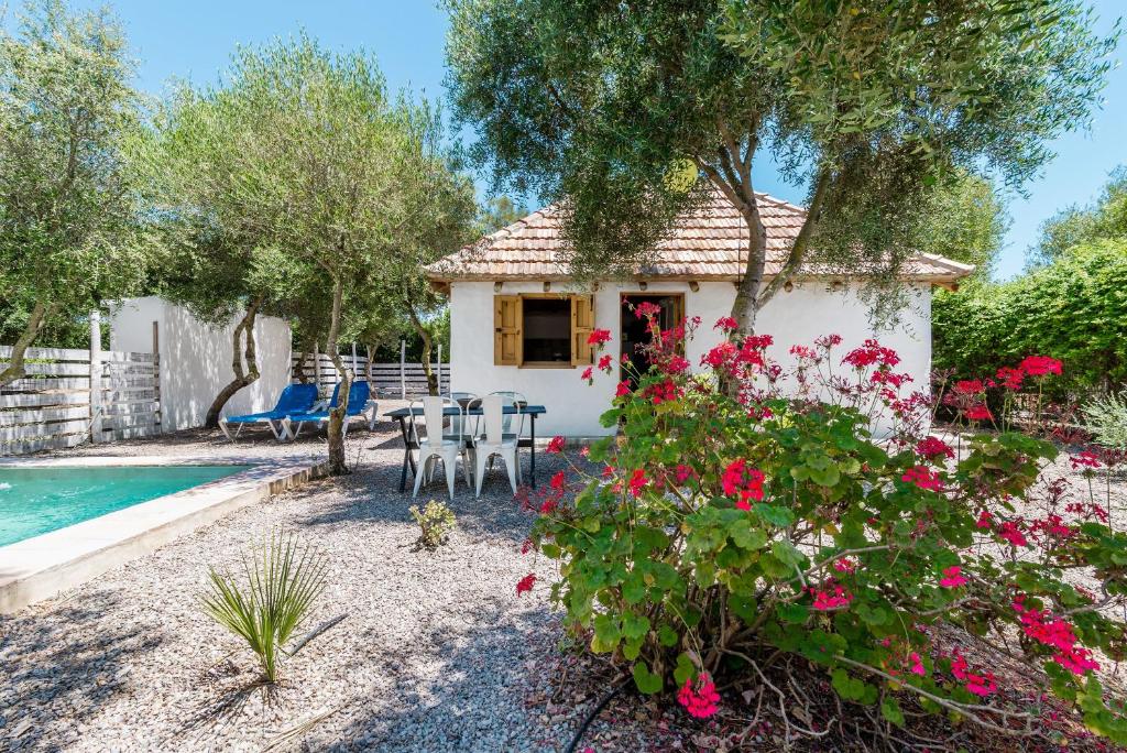 ein kleines Haus mit Pool und Blumen in der Unterkunft Casita-estudio El Castaño in El Palmar