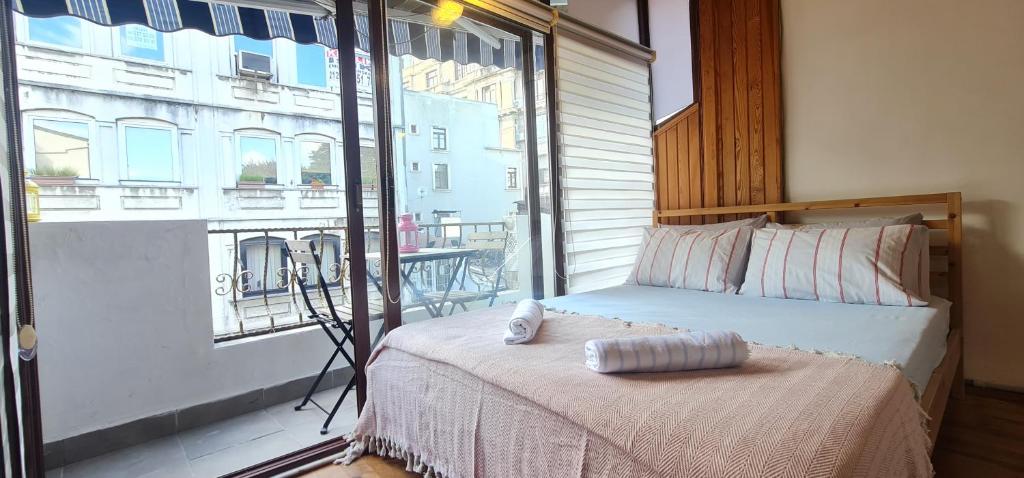 a bedroom with a bed and a large window at Galata Duplex Apt. *Balcony* 1 min to Metro Stn. in Istanbul